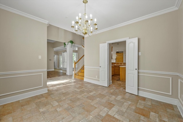 unfurnished dining area with an inviting chandelier and crown molding