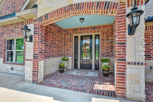 view of exterior entry featuring covered porch