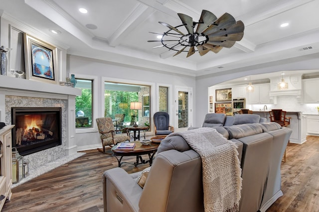 living room with crown molding, ceiling fan, dark hardwood / wood-style flooring, and a fireplace