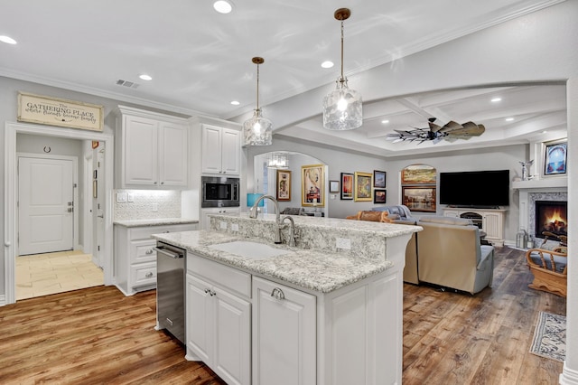 kitchen with white cabinetry, light hardwood / wood-style flooring, a center island with sink, and sink