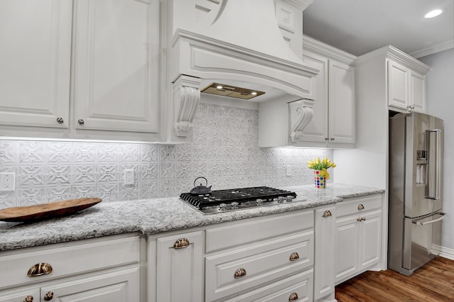 kitchen featuring dark hardwood / wood-style flooring, tasteful backsplash, premium range hood, stainless steel appliances, and white cabinetry