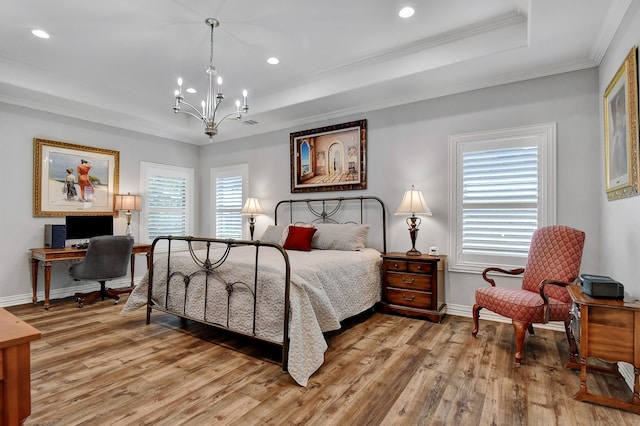 bedroom featuring a raised ceiling, a chandelier, ornamental molding, and light wood-type flooring