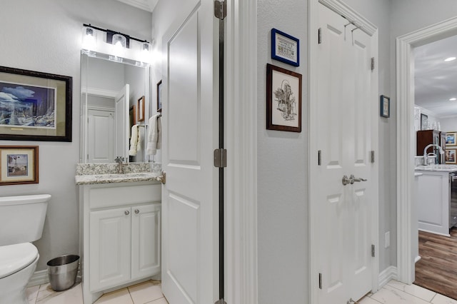 bathroom featuring wine cooler, ornamental molding, vanity, hardwood / wood-style floors, and toilet