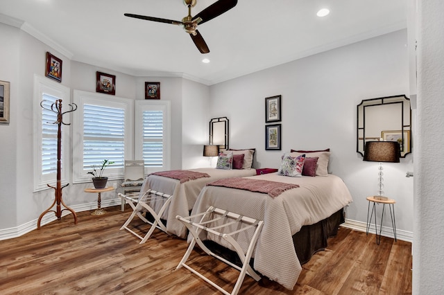 bedroom featuring hardwood / wood-style flooring, ceiling fan, and ornamental molding