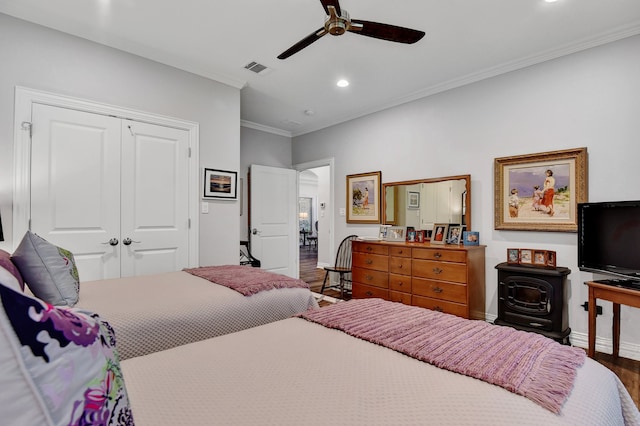 bedroom with hardwood / wood-style floors, ceiling fan, ornamental molding, and a closet