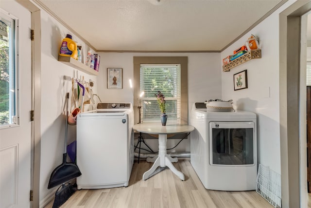 washroom featuring light hardwood / wood-style flooring, washer and dryer, and crown molding