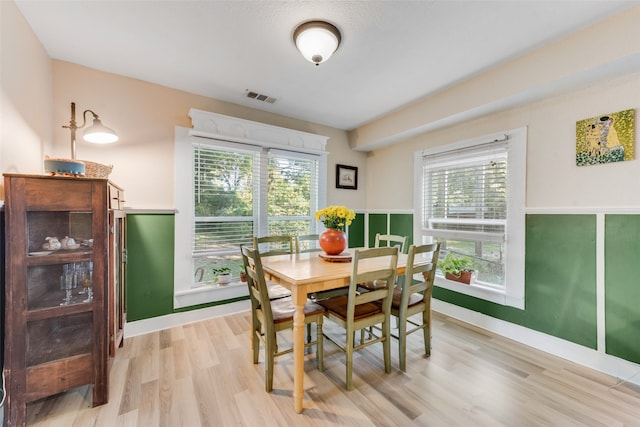 dining space with light wood-type flooring and a healthy amount of sunlight