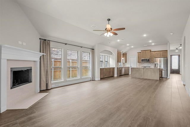 unfurnished living room with a wealth of natural light, light hardwood / wood-style flooring, and lofted ceiling