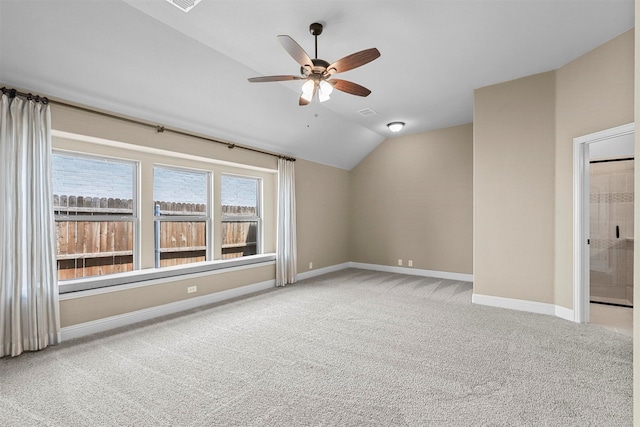 carpeted spare room featuring ceiling fan and vaulted ceiling