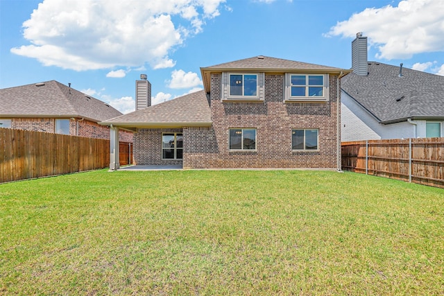 rear view of house with a lawn and a patio