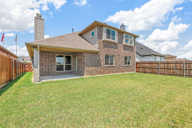 rear view of house with a lawn and a patio