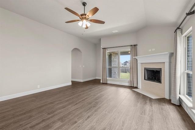 unfurnished living room featuring ceiling fan, a fireplace, dark wood-type flooring, and lofted ceiling