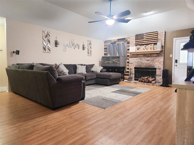 living room featuring lofted ceiling, hardwood / wood-style floors, a fireplace, and ceiling fan