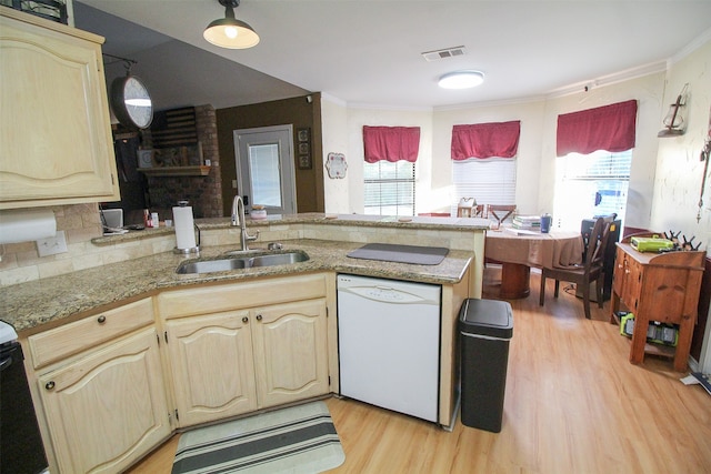 kitchen with a healthy amount of sunlight, sink, light wood-type flooring, and dishwasher