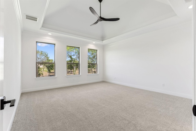 unfurnished room with carpet, ceiling fan, a raised ceiling, and crown molding