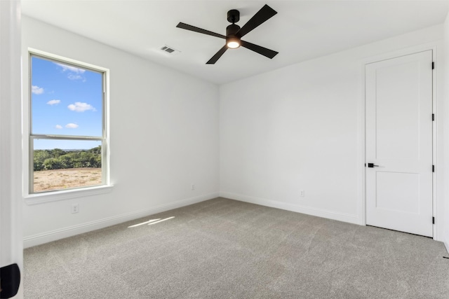 spare room with ceiling fan and light colored carpet