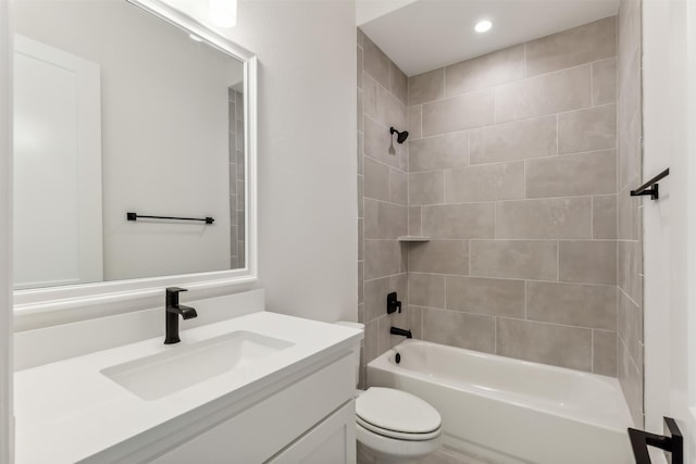 full bathroom featuring vanity, toilet, and tiled shower / bath