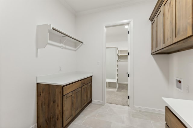 laundry area featuring hookup for a washing machine, light colored carpet, cabinets, and ornamental molding