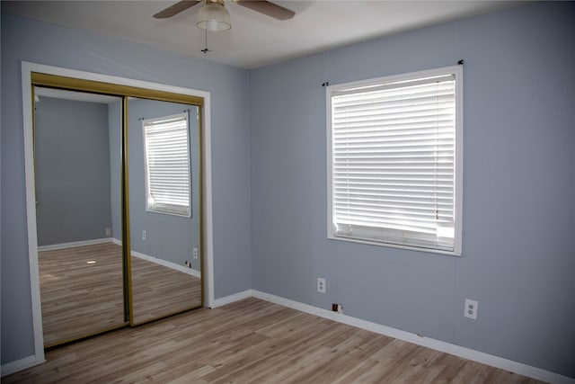 unfurnished bedroom featuring ceiling fan, light hardwood / wood-style flooring, and a closet