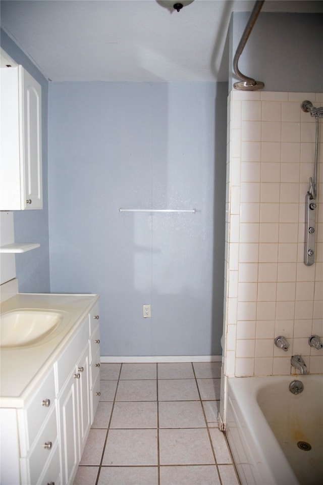 bathroom with tiled shower / bath combo, vanity, and tile patterned flooring