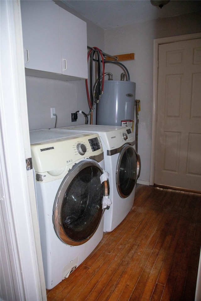 laundry area featuring hardwood / wood-style floors, water heater, washer and clothes dryer, and cabinets