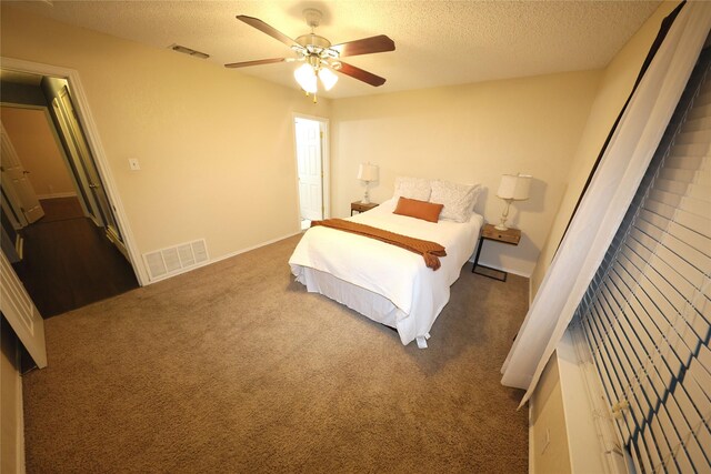 carpeted bedroom with a textured ceiling and ceiling fan