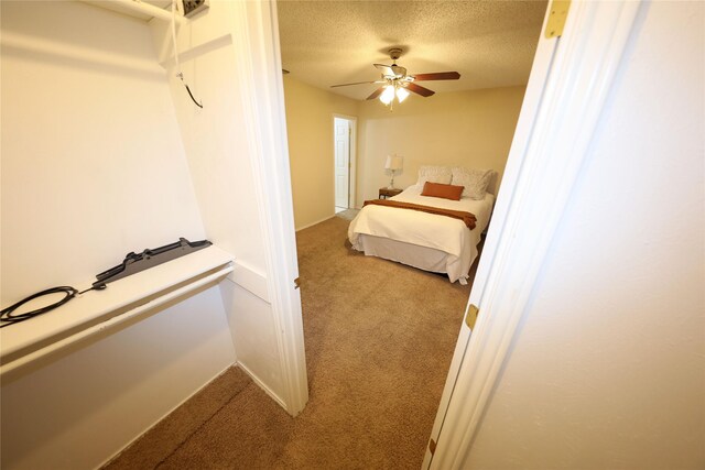 unfurnished bedroom with a textured ceiling, ceiling fan, and carpet