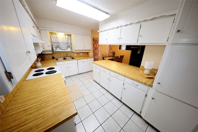 kitchen with white cabinetry, sink, light tile patterned floors, and range