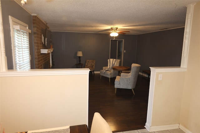 interior space with ceiling fan, a textured ceiling, and wood-type flooring