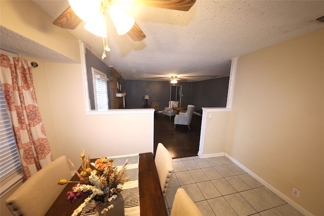 dining area with light tile patterned floors, a textured ceiling, and ceiling fan