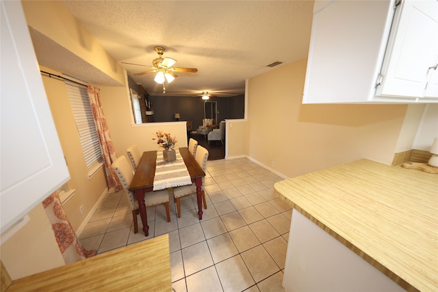 dining room with ceiling fan, a textured ceiling, and light tile patterned floors