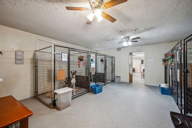 interior space with a textured ceiling and ceiling fan