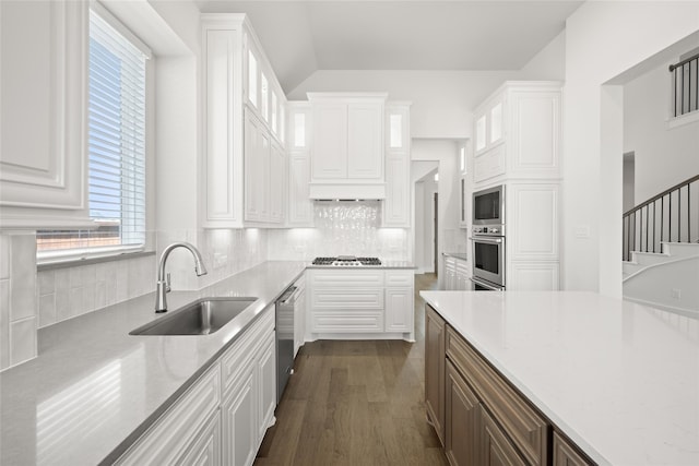 kitchen with white cabinetry, stainless steel appliances, dark hardwood / wood-style flooring, sink, and decorative backsplash