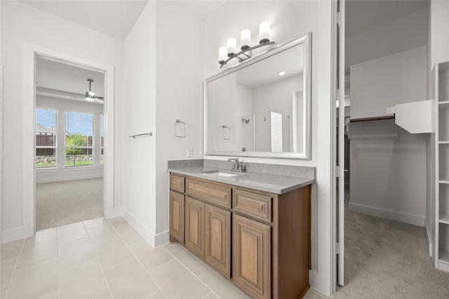 bathroom with tile patterned flooring, vanity, and ceiling fan with notable chandelier