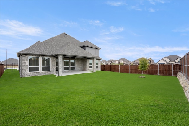 back of house with a lawn and a patio