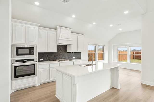 kitchen featuring white cabinetry, a kitchen island with sink, sink, and appliances with stainless steel finishes