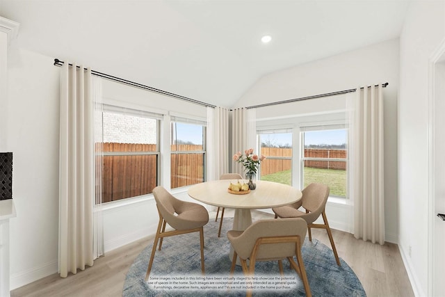 dining area with lofted ceiling and light hardwood / wood-style floors