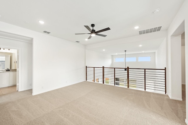 carpeted spare room with ceiling fan