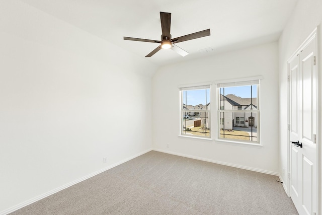 empty room with lofted ceiling, light colored carpet, and ceiling fan