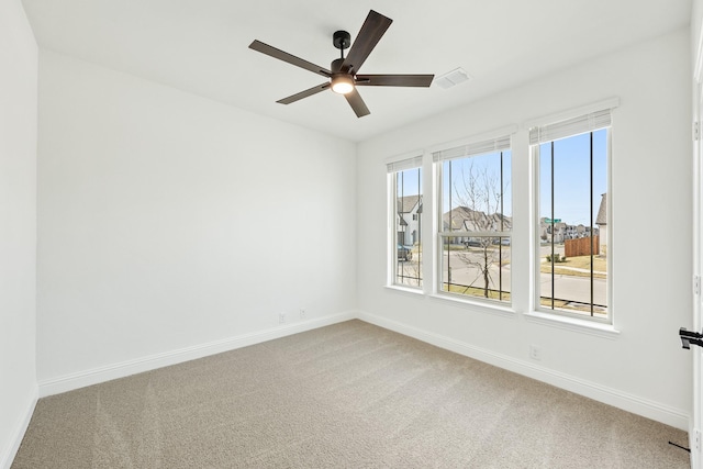 carpeted spare room with ceiling fan