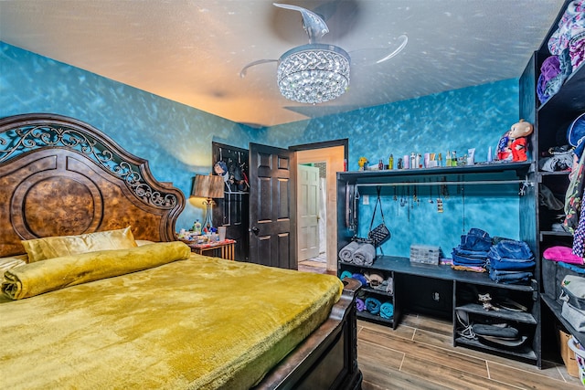 bedroom with a textured ceiling and hardwood / wood-style flooring