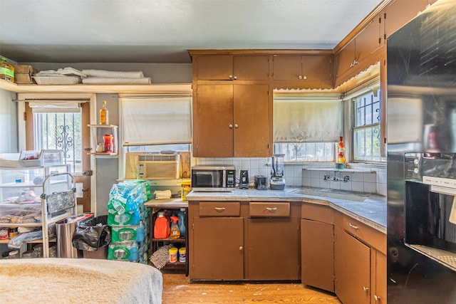 kitchen with refrigerator with ice dispenser, cooling unit, light hardwood / wood-style floors, backsplash, and sink