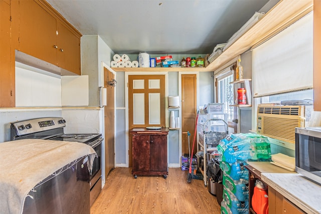 kitchen with stainless steel appliances, cooling unit, and light hardwood / wood-style floors