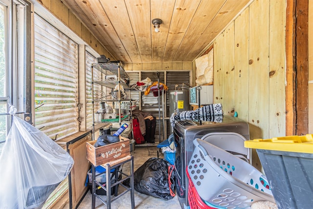 laundry room with electric water heater, wooden walls, a healthy amount of sunlight, and wood ceiling