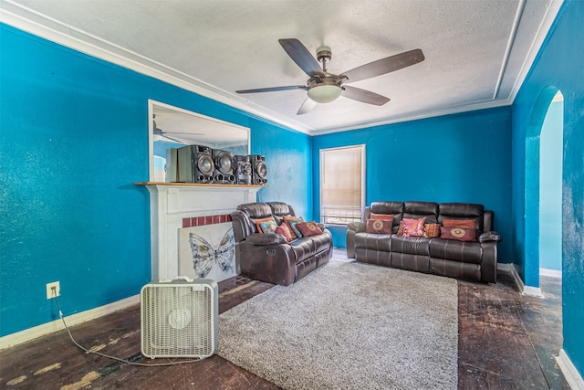 living room with ceiling fan, ornamental molding, and a textured ceiling