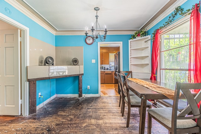 dining space featuring crown molding, hardwood / wood-style floors, and an inviting chandelier