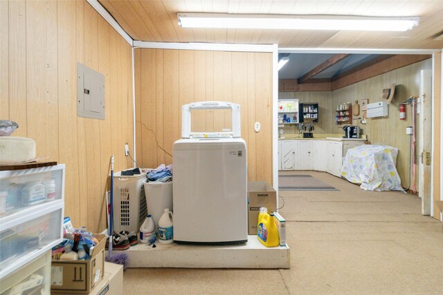 basement featuring wooden walls, electric panel, and wood ceiling