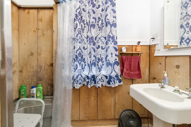 bathroom featuring wooden walls