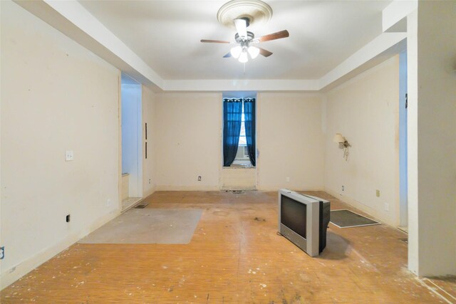 spare room with ceiling fan and a raised ceiling