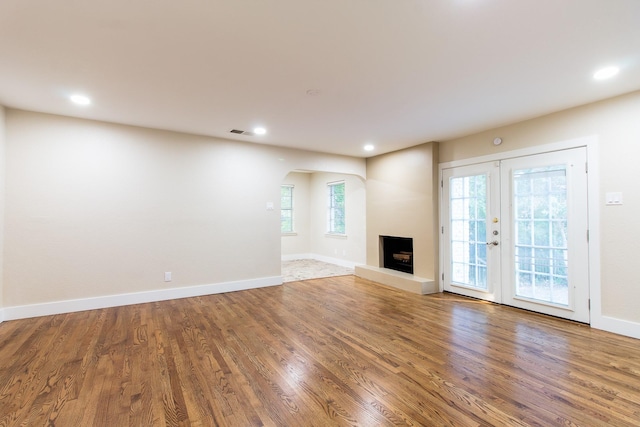 unfurnished living room with wood-type flooring and french doors